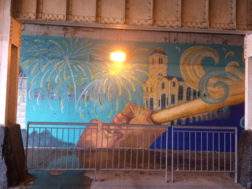 A mural painted on the side of a bridge.