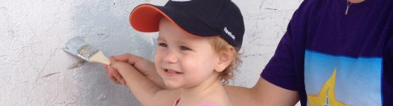 A woman is painting a wall with a brush.