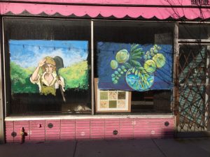 Two paintings in the window of a store.