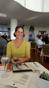 Woman sitting in a restaurant, smiling.
