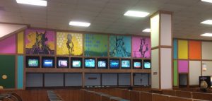 Wall paintings behind digital screens