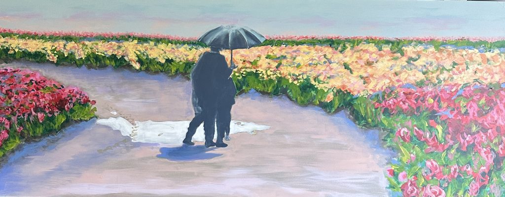 Couple with umbrella walking in flower field.