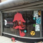 A mustache and a pipe painted on a store window