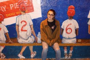 A girl sitting in front of a wall painting