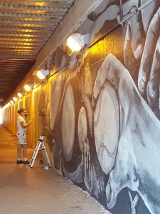 A woman painting a long wall