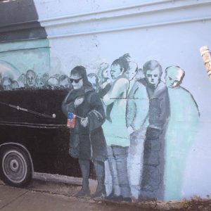 painting of 4 individuals looking at the car