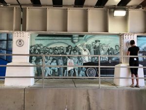 A wall painting of people and a car