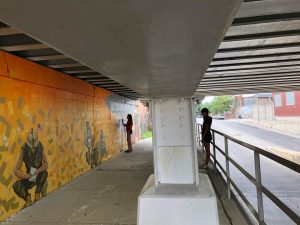 A woman painting a wall and a woman watching her