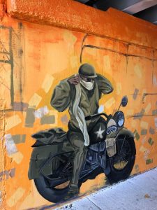 Painting of a man on a bike