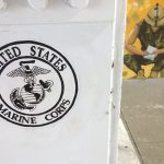 United States Marine Corps logo on a white pillar in front of a painted wall
