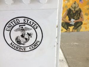 United States Marine Corps logo on a white pillar in front of a painted wall