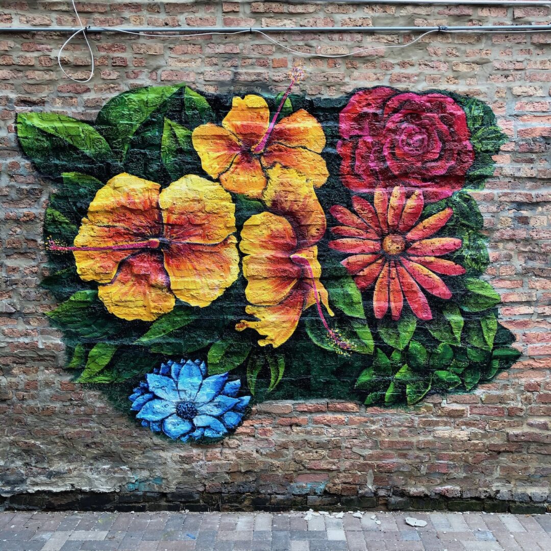 A colorful mural painted on the side of a brick wall.