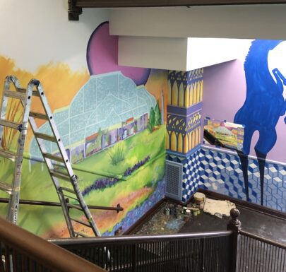 A mural is being painted on the wall of a building.