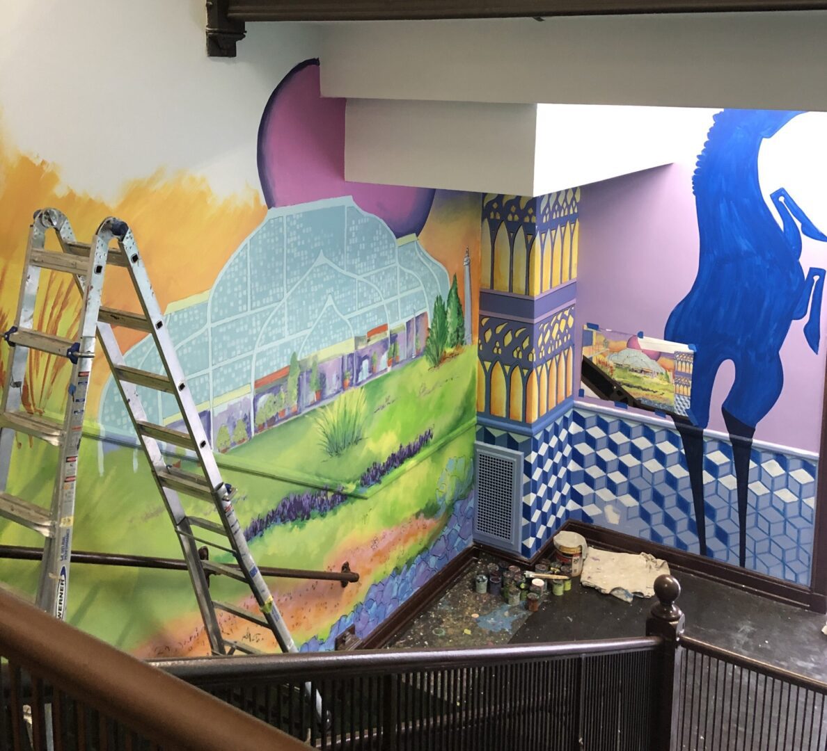 A mural is being painted on the wall of a building.