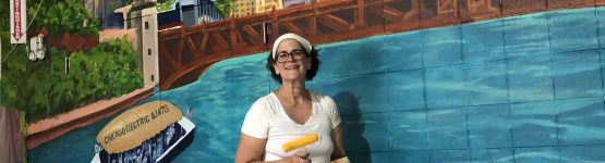 A woman painting a lake on the wall