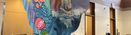 A mural of a woman sitting at a desk in a library.