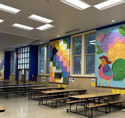 School cafeteria with colorful wall murals.