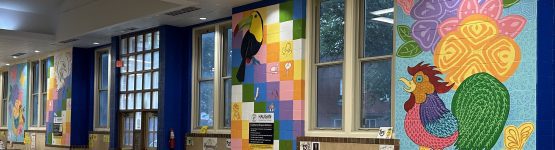 School cafeteria with colorful wall murals.