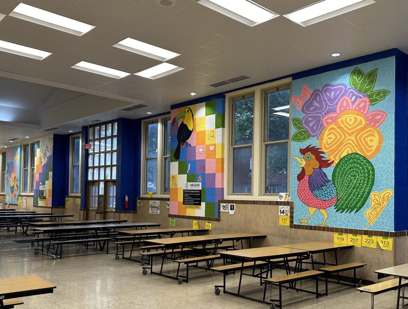 School cafeteria with colorful wall murals.