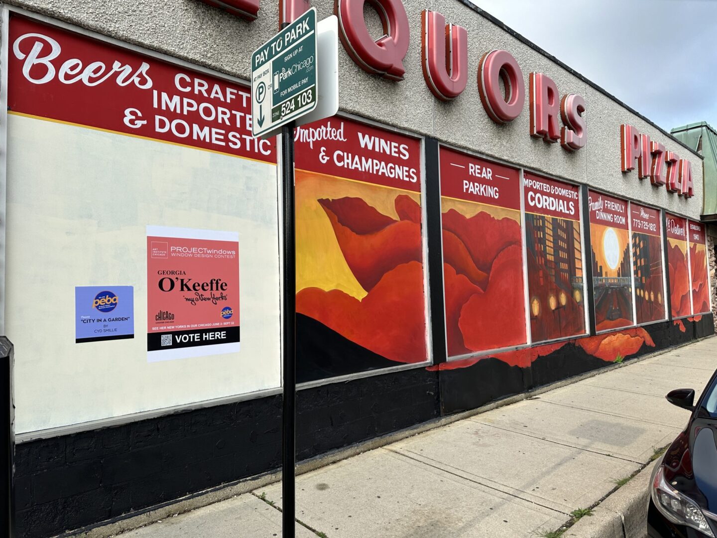 Liquor store mural with parking sign.