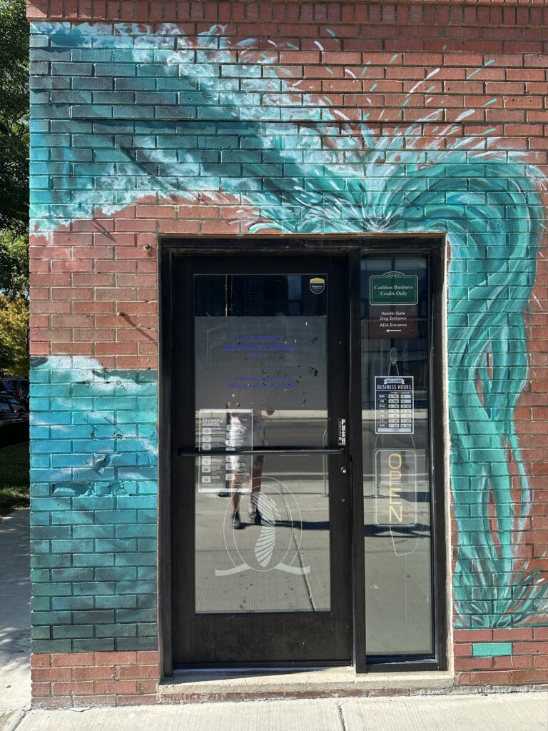 Brick wall with teal wave mural.